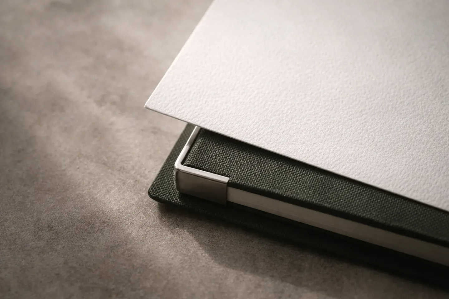 Detalle editorial de escritorio con cuaderno y planta.